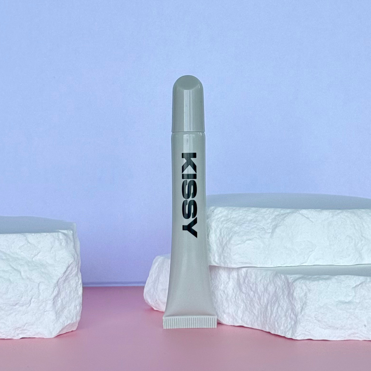 Closed tube of Kissy Gloss Natural nude lip gloss in a studio setting